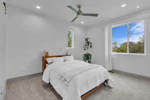 Bedroom with light colored carpet, ceiling fan, and recessed lighting