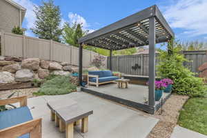 Fenced backyard featuring a pergola, an outdoor hangout area, and a patio