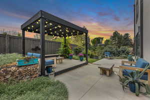 Fenced backyard featuring outdoor seating, a patio area, a deck, and a pergola
