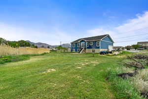 Rear view of house with a yard and a mountain view