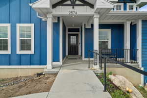 Entrance to property featuring board and batten siding and a porch