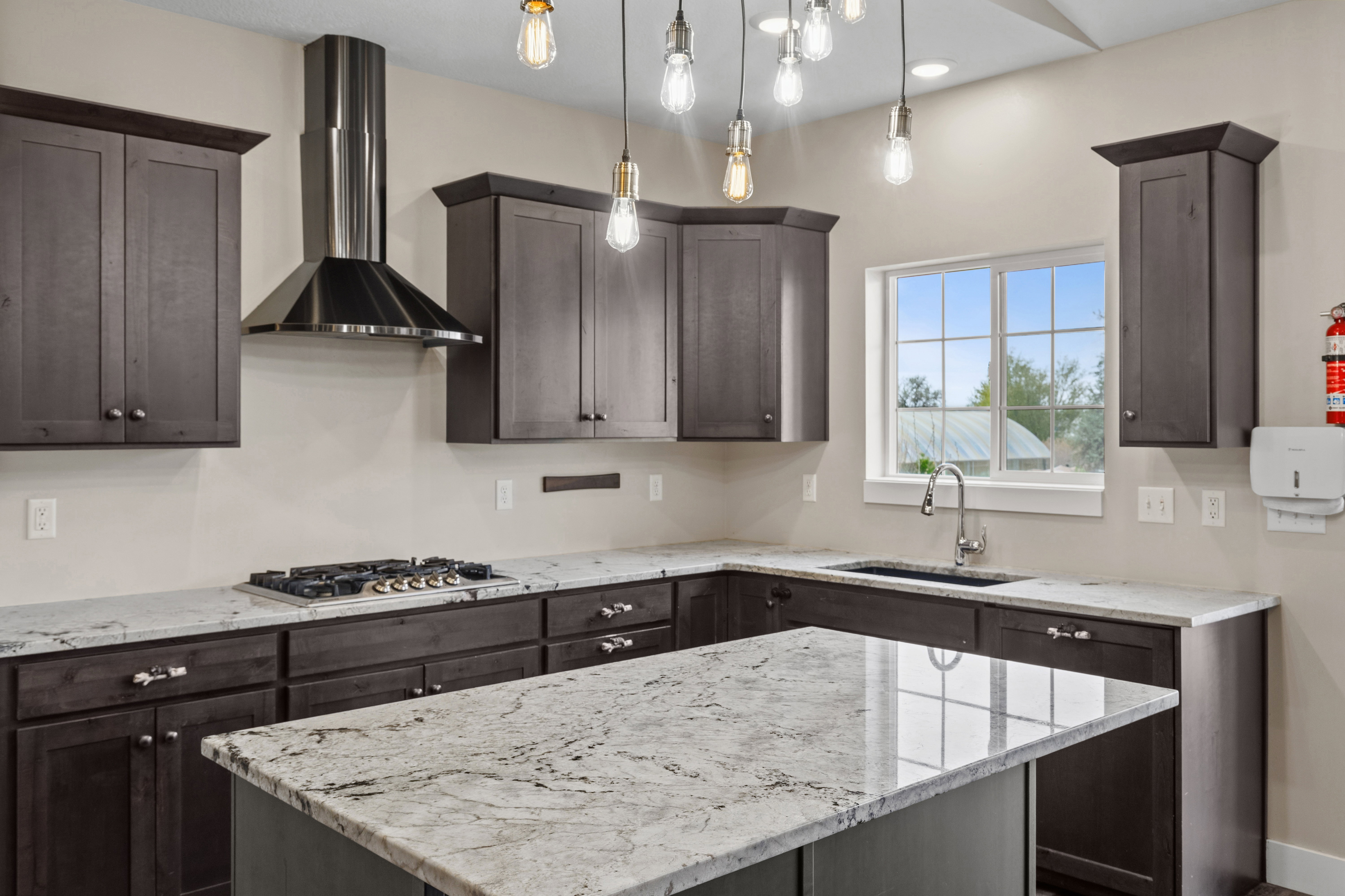 Kitchen featuring light stone countertops, dark wood finish cabinets, and a kitchen island