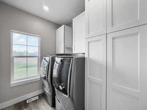 Laundry room with cabinet space, washer and dryer, light wood-type flooring, and recessed lighting