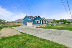 View of front of house with a mountain view, concrete driveway, board and batten siding, and a garage