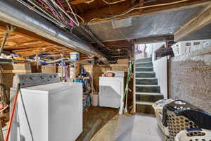 Unfinished basement with stairway and separate washer and dryer