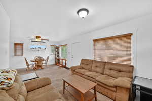 Living room featuring carpet and ceiling fan