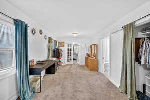 Bedroom featuring light colored carpet and baseboards