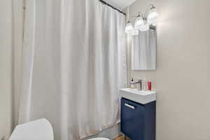 Bathroom with vanity and shower / bath combo with shower curtain