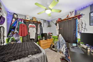 Carpeted bedroom featuring ceiling fan