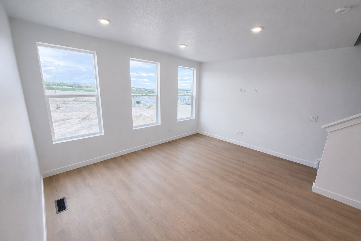 Empty room with light wood finished floors, recessed lighting, and a smoke detector