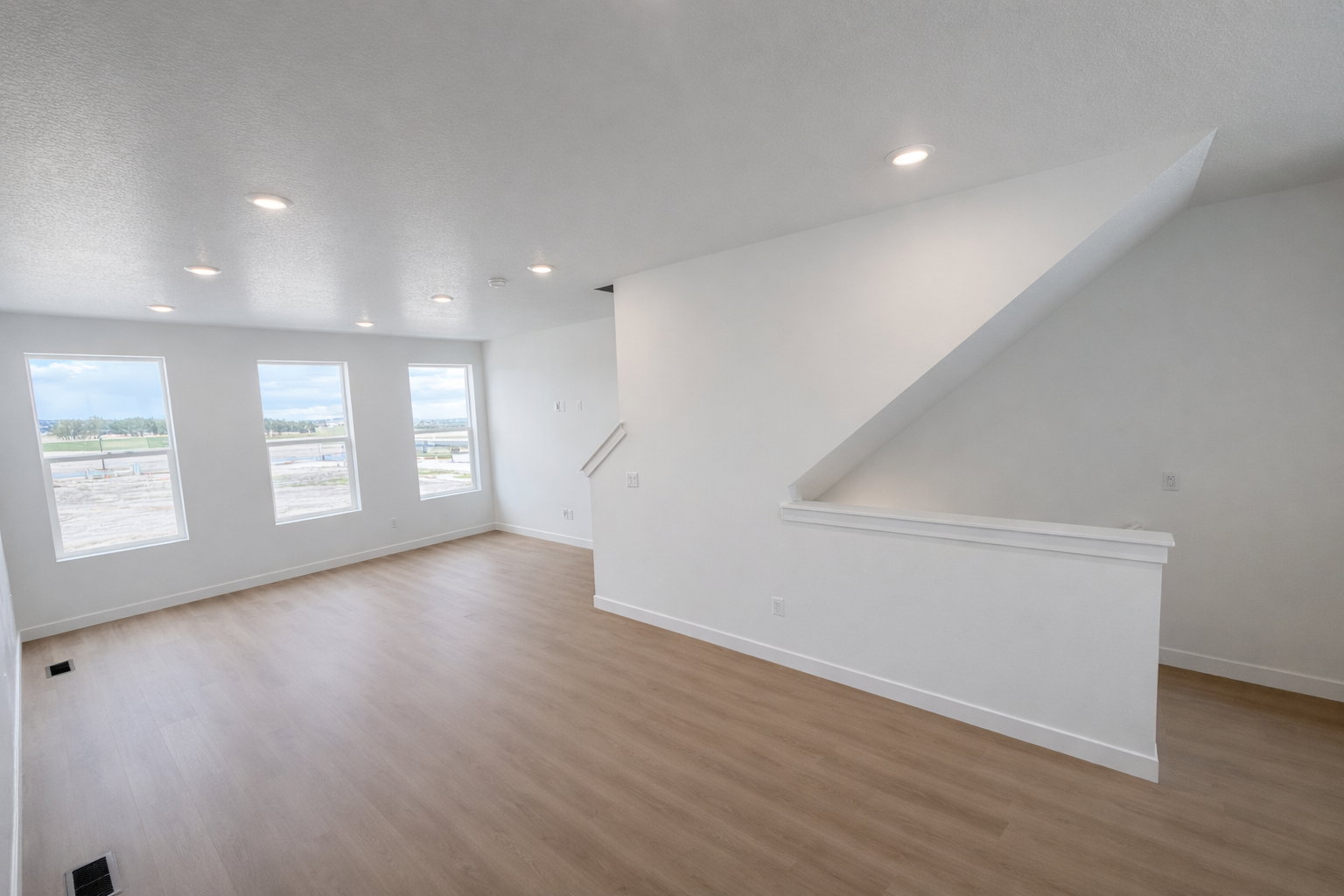 Empty room featuring light wood-type flooring and recessed lighting