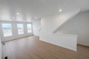 Empty room featuring light wood-type flooring and recessed lighting