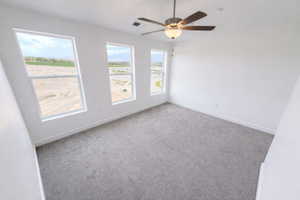 Empty room featuring carpet and a ceiling fan