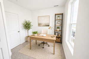 Home office featuring light carpet and baseboards