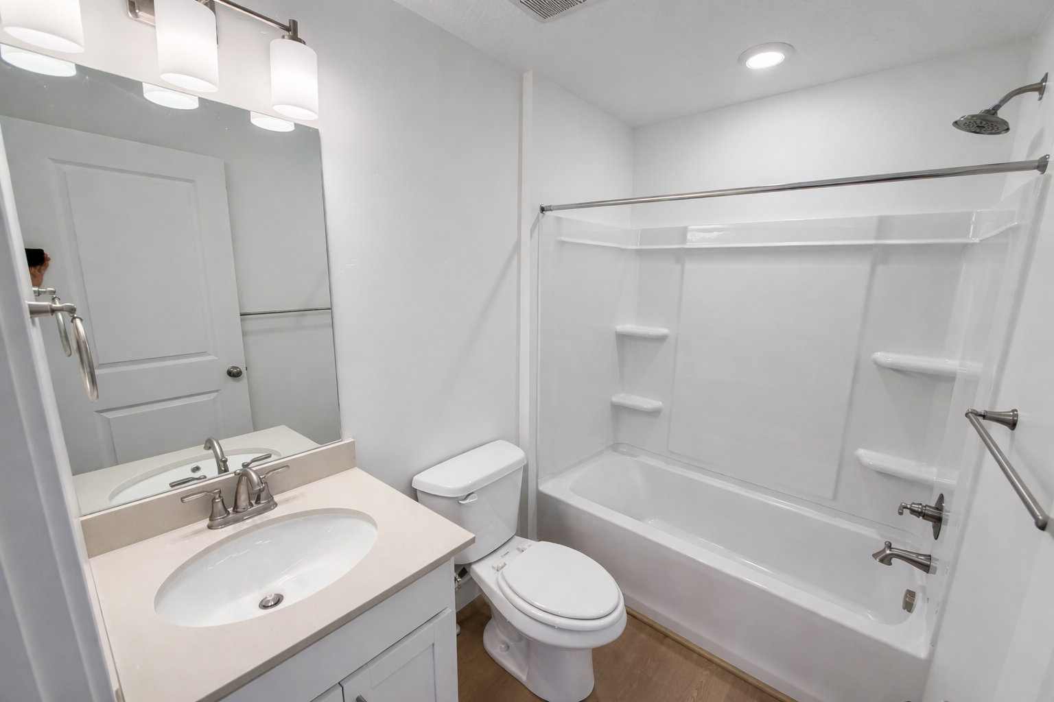 Bathroom featuring vanity, bathtub / shower combination, and dark wood-style floors