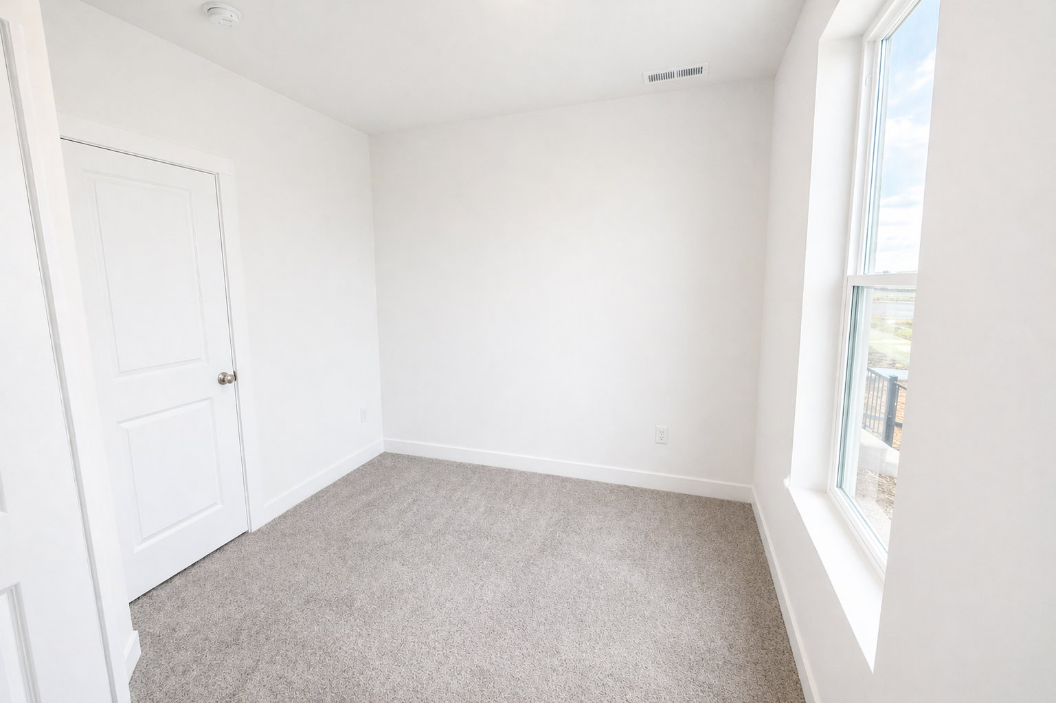 Empty room featuring baseboards and light carpet