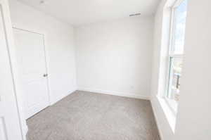 Empty room featuring baseboards and light carpet