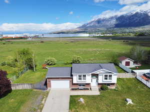 View of front of house with brick siding, driveway, a garage, and a water and mountain view