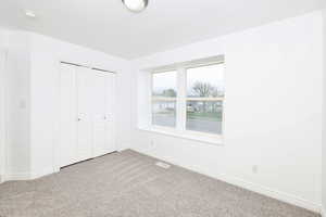 Unfurnished bedroom featuring carpet and a closet