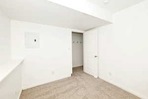 Unfurnished bedroom featuring light carpet, electric panel, and a textured ceiling