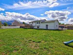 Rear view of property featuring a fenced backyard and a deck with mountain view