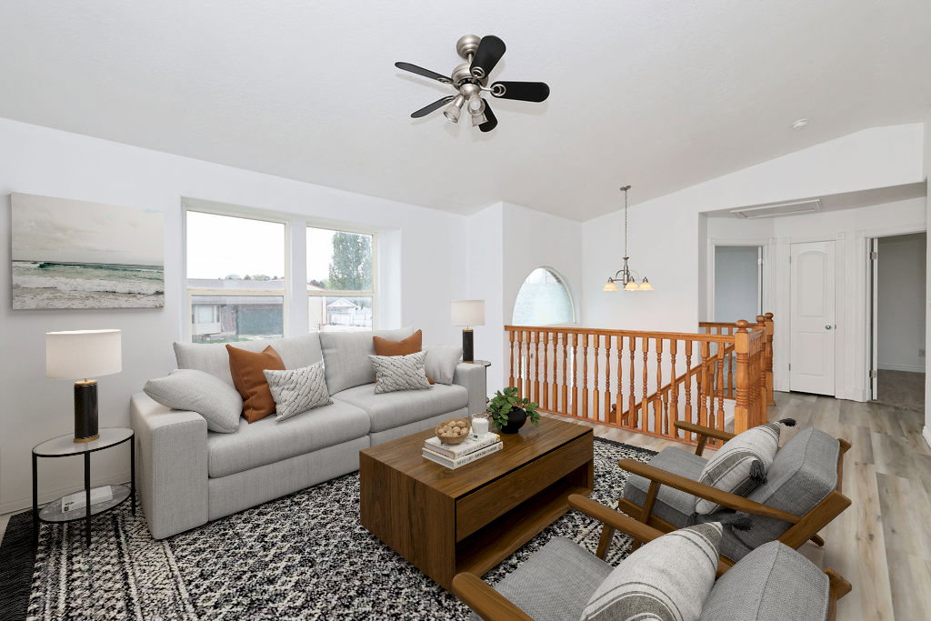 Living room featuring ceiling fan, vaulted ceiling, suspended lighting, and wood finished floors
