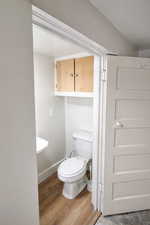 Bathroom with light wood-style flooring and toilet