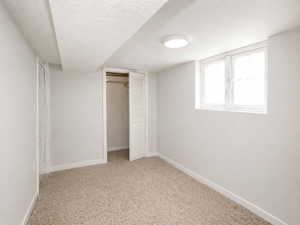 Unfurnished bedroom featuring a closet, light carpet, and a textured ceiling