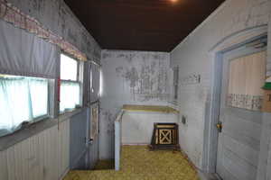 Bathroom featuring brick wall, wood ceiling, and tile patterned floors