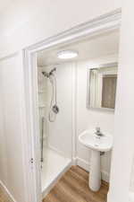 Bathroom featuring light wood-type flooring and a stall shower