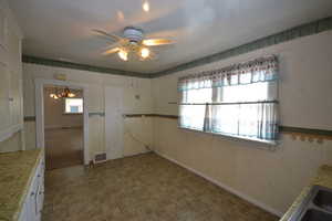Unfurnished dining area with a ceiling fan and a sink