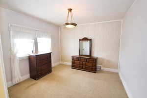 Bedroom featuring light carpet and baseboards