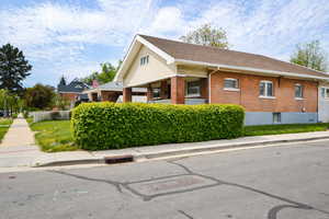 View of side of home featuring brick siding and roof with shingles