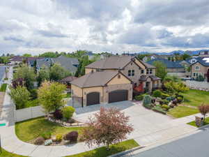 View of front of home featuring stone siding, a residential view, a garage, driveway, and stucco siding
