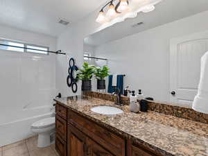Full bathroom with vanity, washtub / shower combination, and light tile patterned flooring