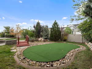Surrounding community featuring an area to practice putting and a gate