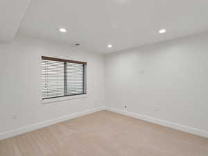 Spare room with light carpet and recessed lighting