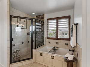 Full bathroom featuring a stall shower, a garden tub, and a textured ceiling