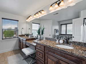 Full bath featuring vanity, healthy amount of natural light, and light tile patterned floors