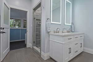 Bathroom featuring double vanity and a shower stall