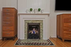 Detailed view of wood finished floors and a fireplace