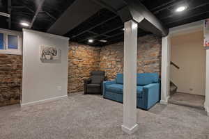 Finished basement featuring stairway and carpet flooring