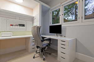 Office with built in desk and light carpet