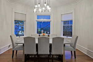 Dining area featuring dark wood finished floors and a chandelier