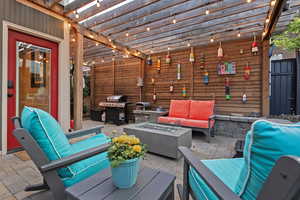 View of patio with an outdoor living space with a fire pit and grilling area