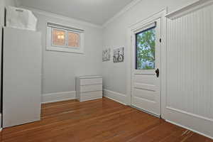 Unfurnished bedroom featuring crown molding and dark wood finished floors