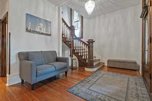 Entrance foyer with wood-type flooring and hanging lights