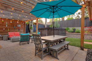 Fenced backyard with outdoor lounge area, a hot tub, and a patio