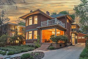 Contemporary home with a chimney, brick siding, a balcony, and driveway