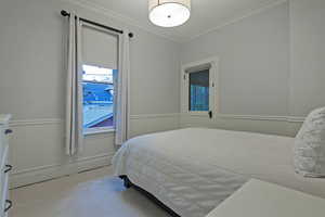 Bedroom featuring wainscoting and ornamental molding